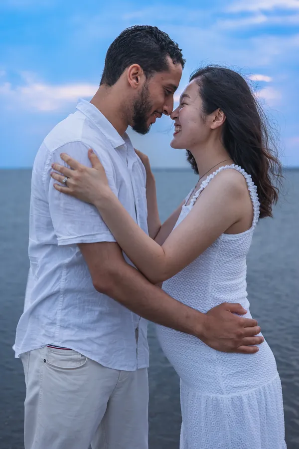 Expectant couple embracing on the beach