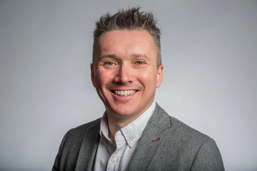Executive headshot against a grey studio backdrop