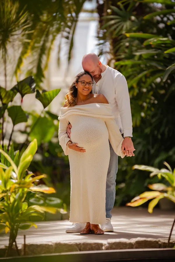 Expectant couple in a sunlit garden