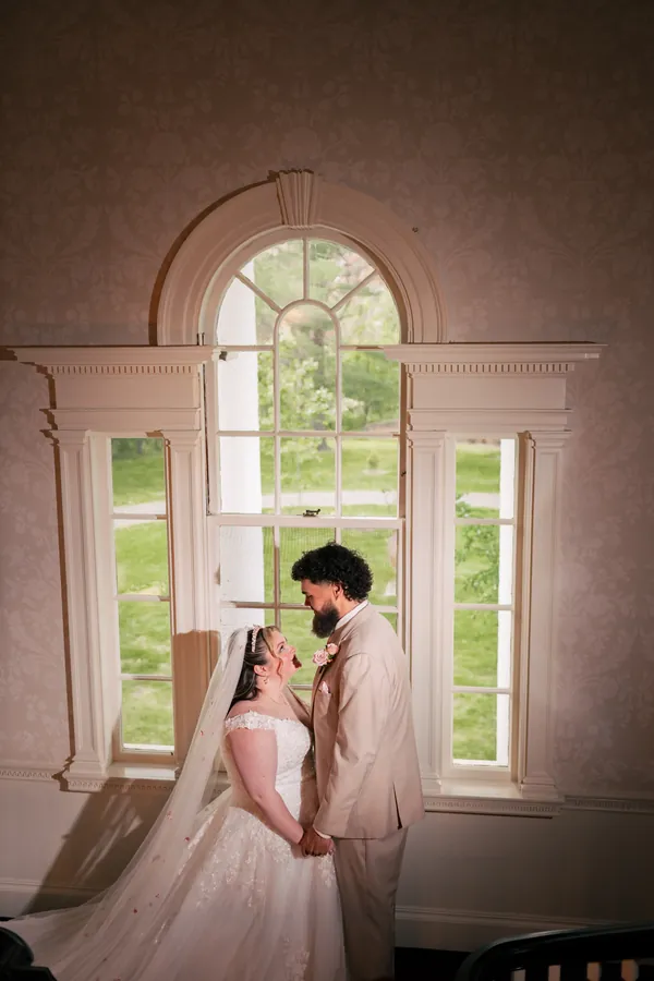 Bride and groom at an arched window